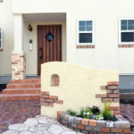 丸い開口が可愛い、塗り壁とスリムレンガで門柱